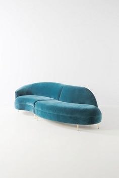 a blue couch sitting on top of a white floor