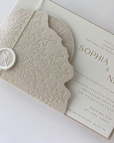 an elegant wedding card with a monogrammed design on the front and back side