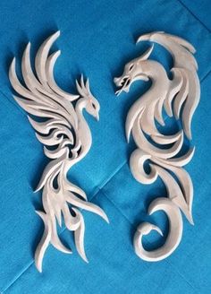 two white dragon figurines sitting on top of a blue cloth