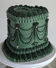 a three tiered green cake with beaded decorations