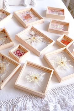 a bunch of framed pictures sitting on top of a white table covered in doily