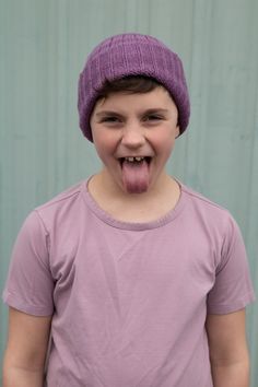 a young boy making a funny face with his tongue out