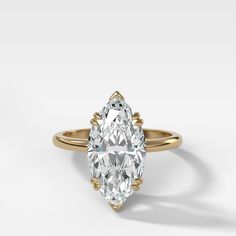 a pear shaped diamond engagement ring on a white background