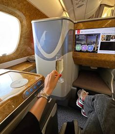 a person holding a glass of champagne on an airplane