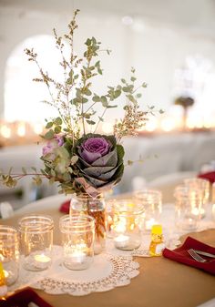 several vases with flowers in them sitting on a white tableclothed table cloth