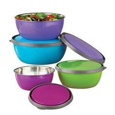 colorful bowls with lids are stacked on top of each other, and one bowl has a salad in it