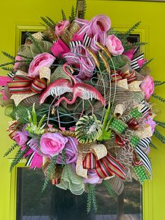 the wreath is decorated with pink flowers and green leaves, along with other decorative items