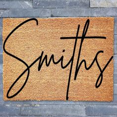 a door mat with the word smiths written in cursive writing on it