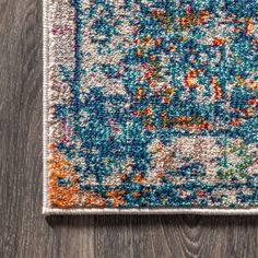 a multicolored area rug on top of a wooden floor