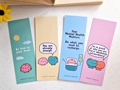 three bookmarks with cartoon characters on them next to a sunflower and an open book