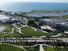 an aerial view of a city by the water with lots of green grass and trees