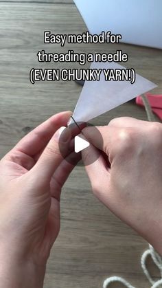 someone is holding a paper airplane with the words easy method for threading a needle even chunky yarn