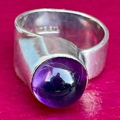 "Here's a modernist amethyst ring that was handcrafted in the studio of the Finnish Australian gold and silversmith Tor Schwanck.  Born in 1935 into a metalworking family, Tor could trace this heritage back to a 15th-century armourer. He was four when the Soviets bombed Helsinki and became one of thousands of children evacuated to foster families in Sweden. He completed his five-year bench apprenticeship in Malmö, studying design and fine art at night. In 1961 he arrived in Melbourne with \"noth Modern Amethyst Ring With Bezel Setting, Modern Hallmarked Amethyst Ring For Formal Occasions, Modern Sterling Silver Amethyst Ring For Formal Occasions, Polished Vintage Amethyst Ring, Modern Sterling Silver Amethyst Ring, Unique Collectible Amethyst Ring, Modern Polished Amethyst Ring, Modern Sterling Silver Amethyst Ring With Polished Finish, Unique Amethyst Collectible Ring