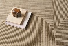 a book with a wooden stamp on top of it sitting on a carpeted floor