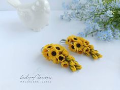 two sunflowers are sitting next to each other on a table with flowers in the background