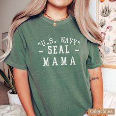 "Perfect gift for Mom. Proud Navy Mom Shirt, Proud Navy Mom Shirt, Navy Graduation Shirt, Navy Camp Shirt, Proud Navy Family Shirt, Sailor Shirt  This is a premium Comfort Colors®, garment dyed tee. This T-shirt is perfect for giving you a relaxed stylish look. What makes this Tee so soft, comfy, and fashionable is the 100% premium ring-spun cotton and double-needle stitching. Perfect for indoors and out. Whether you're working from home, sipping tea at your favorite coffee shop, or on your way to a concert. This navy mom tee will be a welcomed addition to your wardrobe, or as a gift. Select from a large variety of gorgeous colors designed to mimic the rich diversity found in nature itself. Inspired by our veterans and their moms.  This is a standard size Comfort Colors® relaxed fit tee. I Green Cotton Shirt With Letter Print, Green Cotton Shirt With Text Print, Navy Cotton Tops With Letter Print, Navy Cotton Top With Letter Print, Navy Graphic Print Cotton Tops, Navy Cotton Graphic Print Shirt, Navy Cotton Tops With Graphic Print, Navy Cotton Shirt With Graphic Print, Navy Cotton Top With Graphic Print