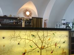 there is a bar with birds on the tree and deers on the wall behind it