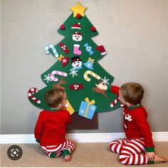 two children are playing with a christmas tree