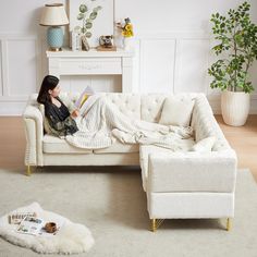 a woman sitting on a couch reading a book