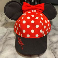 Authentic Merchandise Made Exclusively For Sale At Disneyland Top Your Day At The Happiest Place On Earth W/ Minnie's Polka Dot Baseball Cap Trimmed In Her Trademark Ears & Bow, Plus Embroidered ''Signature'' Accent On The Brim Of The Hat In Minnie's Bright Red Color Baseball Cap W/ Mouse Ears & Bow Embroidered Minnie Mouse ''Signature'' On Bill Embroidered Classic Disneyland Logo On Back Polka Dot Print Canvas Body Adjustable Snapback Strap For Secure Fit One Size Fits Most Girls Adjustable Minnie Mouse Cap, Black Mickey Mouse Cap, Casual Black Mickey Mouse Hat, Black Adjustable Minnie Mouse Hat, Adjustable Black Minnie Mouse Hat, Red Mickey Mouse Adjustable Hat, Fun Mickey Mouse Themed Hat One Size Fits Most, Adjustable Red Mickey Mouse Hat, Adjustable Mickey Mouse Fun Hat