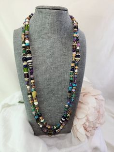 This is my Rhapsody Necklace, a 58" long, one-of-a-kind necklace made from thousands of different beads from around the world. Many of the beads are from a broken piece of jewelry that I will never be able to repair or replace so they're kind of special. Glass, ceramic, crystal, semi-precious stones and crystals, metal beads, pearls, wooden beads, and more come together in a long, kaleidoscope confetti rope of colors that cannot be duplicated. The Rhapsody Multichain Necklace is 51" long and can be worn in many different ways for many different occasions and look stunning every time. This item ships free to any address in continental USA. Unique Long Beaded Necklace With Faceted Beads, Bohemian Long Necklace With Faceted Round Beads, Multi-strand Czech Glass Beaded Necklace With Polished Beads, Bohemian Multi-strand Long Necklace With Faceted Beads, Bohemian Long Multi-strand Necklace With Faceted Beads, Bohemian Long Crystal Necklace With Polished Beads, Spiritual Beaded Lariat Long Necklace, Healing Multi-strand Colorful Beaded Necklaces, Long Gemstone Beads Necklace