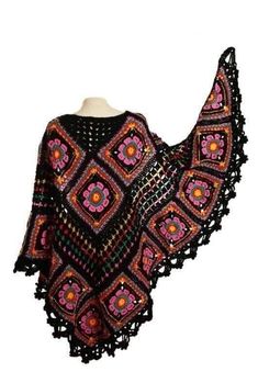 a black and pink crocheted shawl on a mannequin