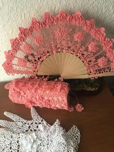 pink crocheted doily next to an old hand fan