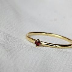 Description: This delicate and refined ring features a tiny 2mm AAA Garnet gemstone set in 925 sterling silver with the option of gold plating.  This ring is perfect for stacking or wearing solo to add a subtle touch of style.  Care Tips for the Gold plated Version: This ring is gold-plated, so it needs a little extra love to keep it looking great. Here's how to make it last: Avoid harsh chemicals: Keep your ring away from perfumes, lotions, and cleaning products, as they can wear off the gold p Elegant Anniversary Birthstone Ring, Fine Jewelry Ruby Stackable Rings As Gift, Elegant Birthstone Ring For Promise, Gemstone Midi Promise Ring In Fine Jewelry Style, Garnet Birthstone Promise Rings, Classic Crystal Birthstone Ring For Gift, Dainty Birthstone Midi Rings For Gifts, Dainty Ruby Birthstone Ring For Anniversary, Tiny Round Birthstone Ring For Anniversary