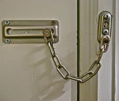 a close up of a door with a metal chain on it's handle and lock