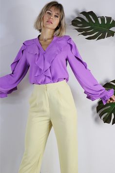 Add some flair to your look with Anita. Featuring ruffles on the bodice of the shirt and the sleeves, she sure makes a statement.Finish the LookPerfect for work or a date night with slacks or a skirtDress it down with denim shorts or your favorite summer skirt.Style FeaturesRuffled detailsButton DownCuffed Wrists Size + FitModel is 5`9" And Wearing Size Small Fits True to Size Fabric100% Polyester Formal V-neck Blouse With Ruffles, V-neck Ruffle Blouse For Night Out, Party Blouse With Ruffle Sleeves, Ruffle Sleeve Blouse With Ruffles For Parties, Chic Ruffle Sleeve Blouse For Party, Chic Formal Blouse With Ruffles, Chic Blouse With Ruffle Sleeves, Chic Ruffled Blouse For Formal Occasions, Chic Blouse With Ruffled Collar For Night Out