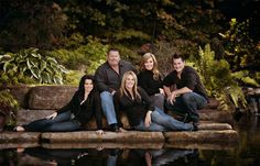 a family posing for a photo by the water