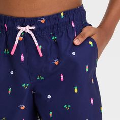 Update your child's swim apparel for swimming, surfing or having fun at the beach with these Shapes Printed Swim Shorts from Cat & Jack™. These lightweight swim trunks are designed with a built-in brief for comfort and extra coverage both in and out of the water. Featuring a colorful print of different tropical-themed shapes on a deep blue backdrop, these mid-rise swim trunks pair with a variety of rash guards, tees or tanks for versatile swimwear options. The full elastic waistband with an adju Fun At The Beach, Blue Backdrop, Blue Backdrops, Swimming Outfit, Printed Swim, Fabric Tape, Beach Fun, Cat & Jack, Pair Of Pants