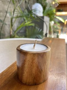 a wooden candle holder sitting on top of a table next to a potted plant