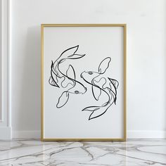 a black and white drawing of two koi fish in a gold frame on a marble floor