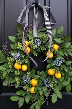 a wreath with lemons and blue berries hanging on a door