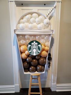 a starbucks coffee cup display with balloons in it