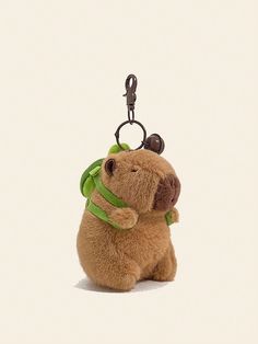 a brown teddy bear with a green ribbon around its neck sitting on a white surface