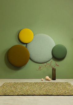 an abstract painting on the wall above a vase with flowers in it and three circles