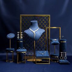 a blue display case with jewelry on it and other items in front of the mannequin