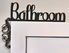 the bathroom sign is hanging on the wall above the toilet paper dispenser