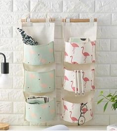 three hanging pockets with flamingos on them and one holding pens, pencils, and an open notebook