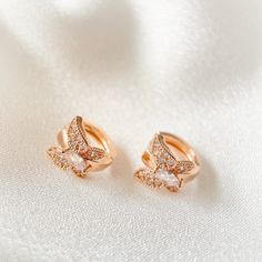 These delicate earrings feature one touch small hoops, made of high-quality rose gold. The charming cubic zirconia butterfly adds a touch of elegance, while the nickel-free post ensures comfort and safety. Perfect for any occasion.  Material: Cubic zirconia, Nickel-free post Size: 1.1cm (Length) The earring posts are in silver which are good for sensitive ears. It is also a perfect gift idea for special events, occassions and celebrations like birthday/anniversary/Valentine's Day/Christmas. Opti Dainty Rose Gold Tarnish-resistant Huggie Earrings, Dainty Rose Gold Cubic Zirconia Huggie Earrings, Rose Gold Tarnish-resistant Dainty Huggie Earrings, Rose Gold Cubic Zirconia Huggie Earrings, Rose Gold Cubic Zirconia Huggie Earrings, Tarnish Resistant, Delicate Rose Gold Hoop Earrings, Rose Gold Cubic Zirconia Small Hoop Huggie Earrings, Dainty Rose Gold Hoop Earrings With Cubic Zirconia, Delicate Rose Gold Small Hoop Huggie Earrings