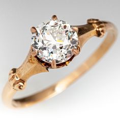 an old - fashioned diamond ring is displayed on a white background, with the center stone in