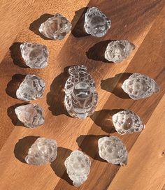 several ice cubes on a wooden table with shadows from the top one is cut in half