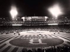 a baseball stadium filled with lots of people and lights on the side of the field