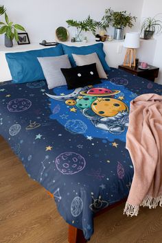 a bed with a space themed comforter and pillows