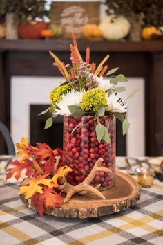 a vase filled with flowers sitting on top of a wooden plate next to a table