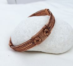 Man bracelet made with braided copper wire and hammered. Your partner's birthday is coming up and you don't know what to give him? Do you want to give a special gift to a family member or friend this Christmas? I propose this elegant and original bracelet. This bracelet has been designed and handmade by me with 1.5 mm copper wire. I braided 3 copper wires which I then forged and moulded to create a copper bracelet for a heavy but comfortable man. I have also aged the bracelet to highlight the wr Male Wire Wrapped Jewelry, Handmade Adjustable Artisan Bangle, Adjustable Brown Copper Braided Bracelets, Adjustable Wire Wrapped Bronze Cuff Bracelet, Artisan Wire Wrapped Adjustable Bracelets, Bohemian Adjustable Copper Bracelets, Adjustable Copper Bangle As A Gift, Adjustable Wire Wrapped Braided Bracelet As Gift, Adjustable Hand Wrapped Bronze Cuff Bracelet