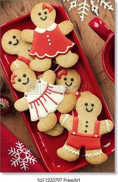 gingerbread cookies decorated with icing and decorations on a red tray next to a cup of coffee