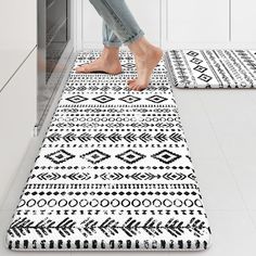 a person standing on a rug in a kitchen